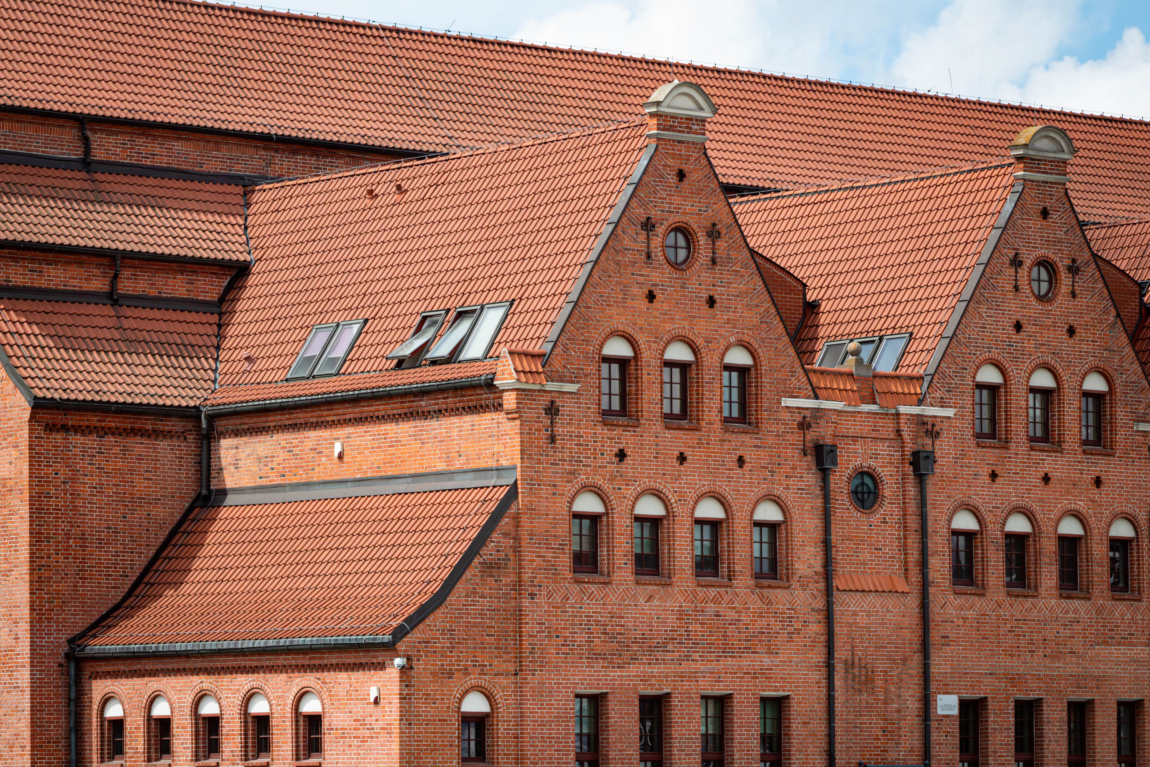 Saniertes Backsteingebäude mit rotem Ziegeldach und Staffelgiebeln